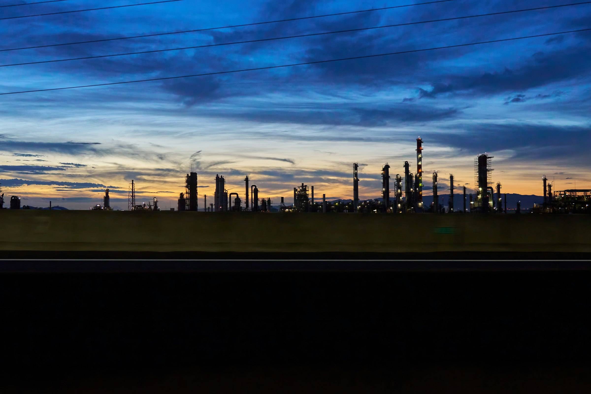 Photograph: an oil refinery with its process columns and pipework.